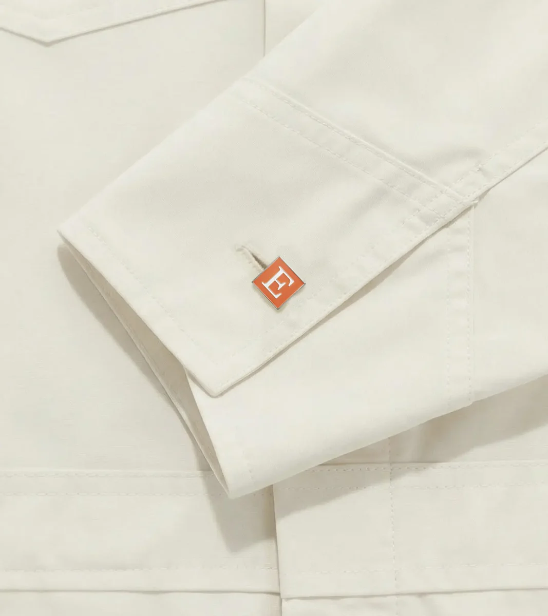 Cream shirt cuff with a small orange Etsy label