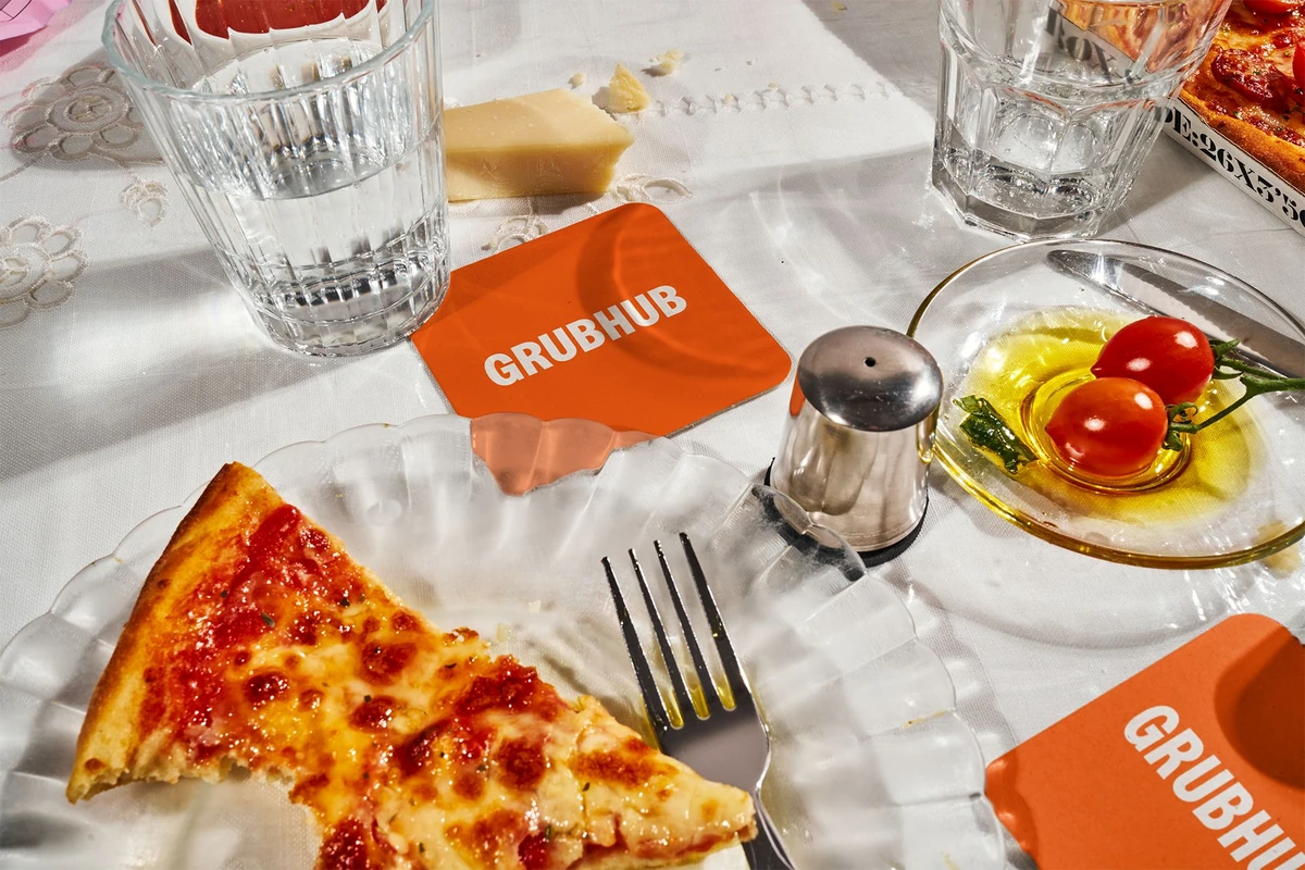 Pizza and drinks on a table with a Grubhub bag