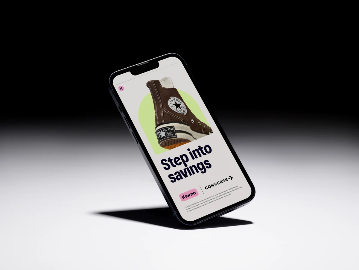 Phone showing the Klarna app in dramatic light