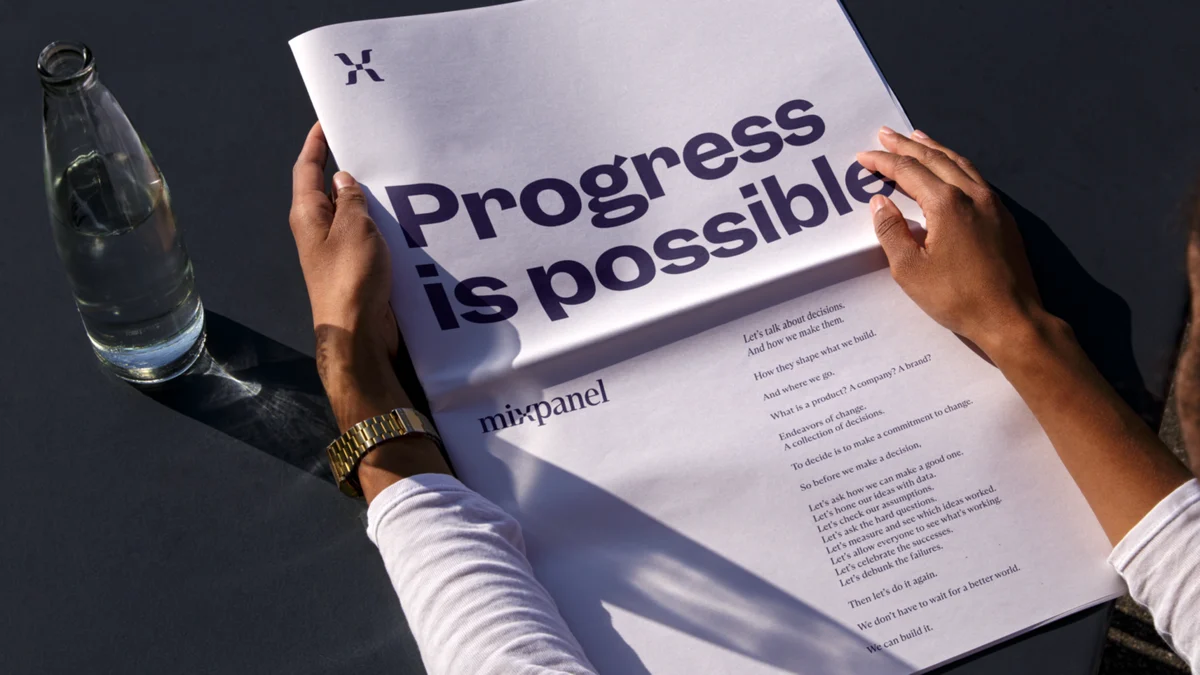 Handen met een Mixpanel-poster 'Progress is possible'