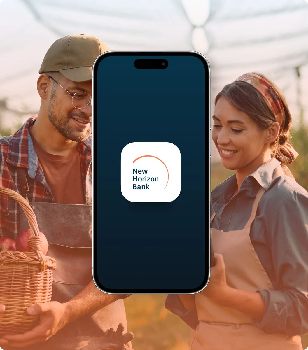 Telefoon met de New Horizon Bank-app, omhooggehouden door een stel op een markt