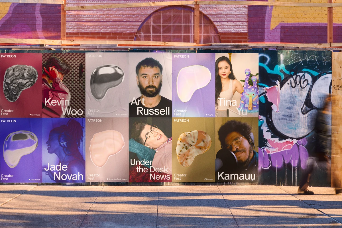 Wall of Patreon creator portrait posters on a street
