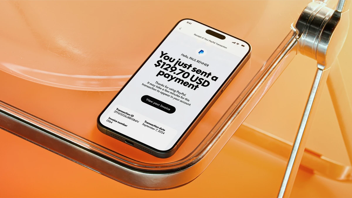 Phone showing a PayPal payment screen on an orange surface