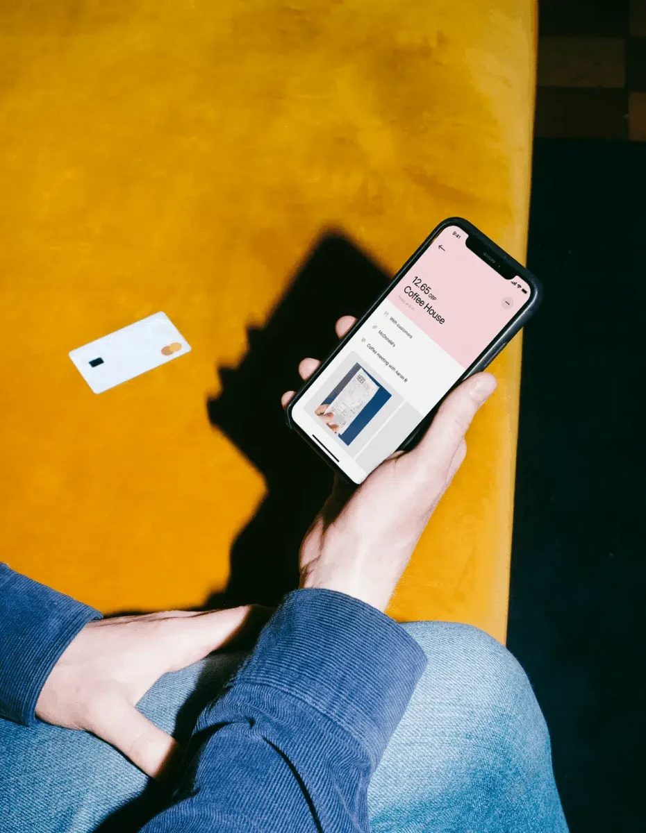 Hand met een telefoon met Pleo op geel