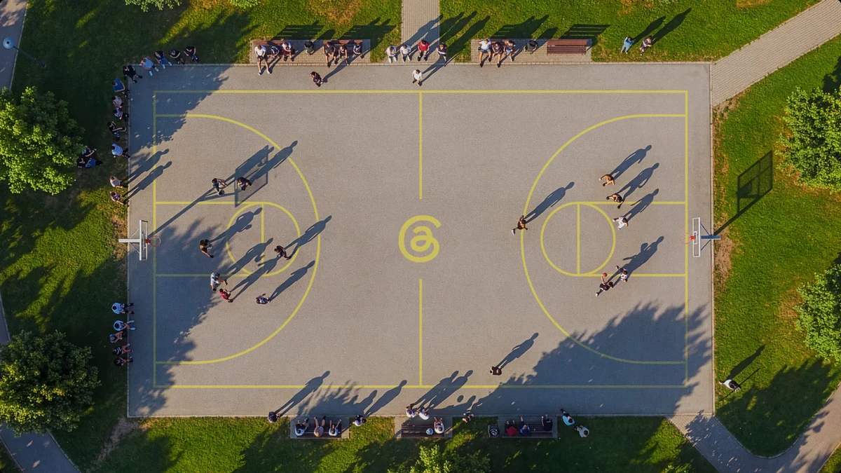 Aerial view of a basketball court painted with the Threads symbol