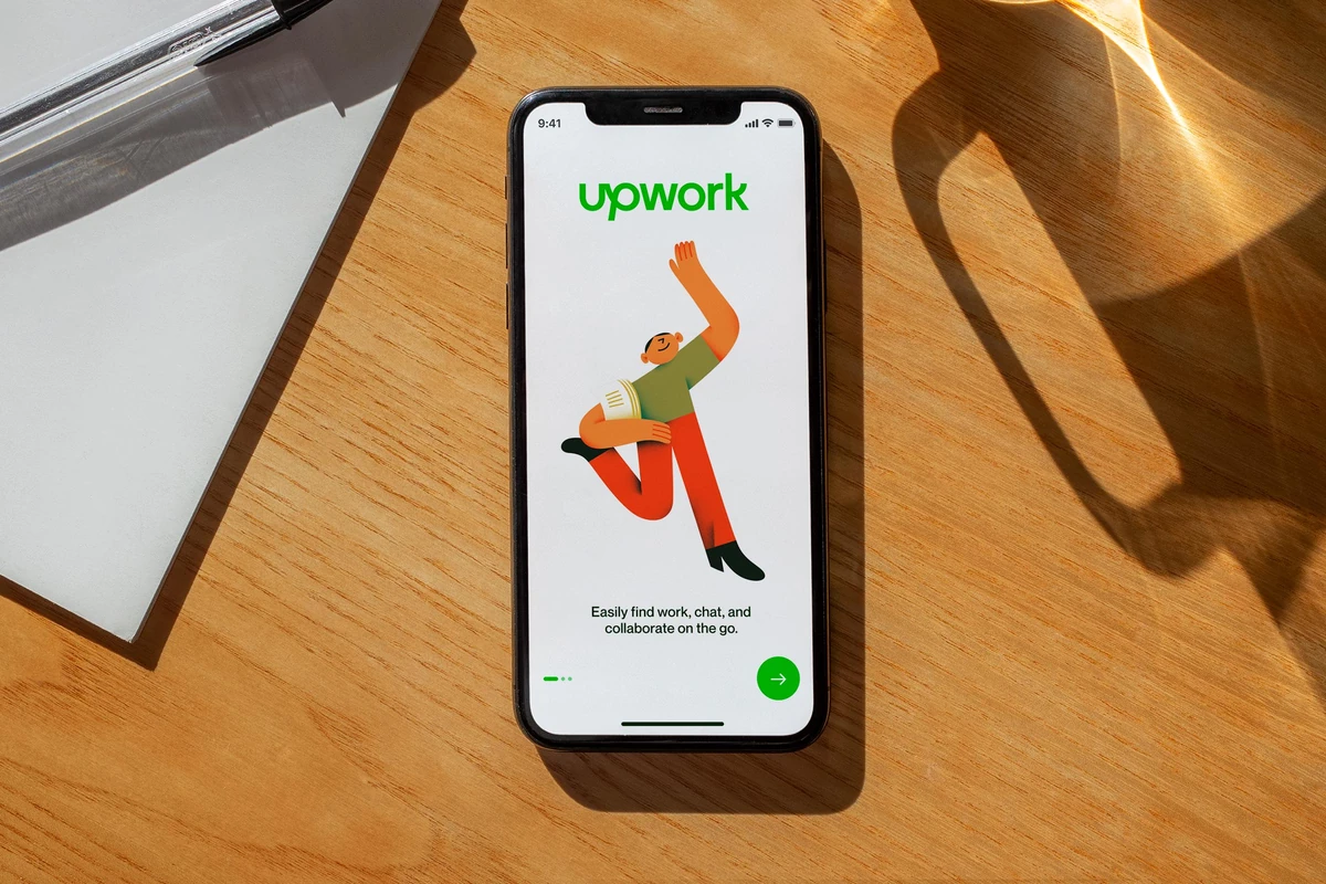 Upwork app on a phone on a wooden table