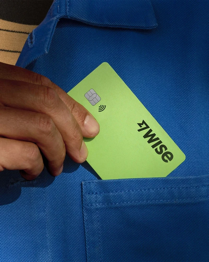 Hand pulling a bright green Wise card from a pocket