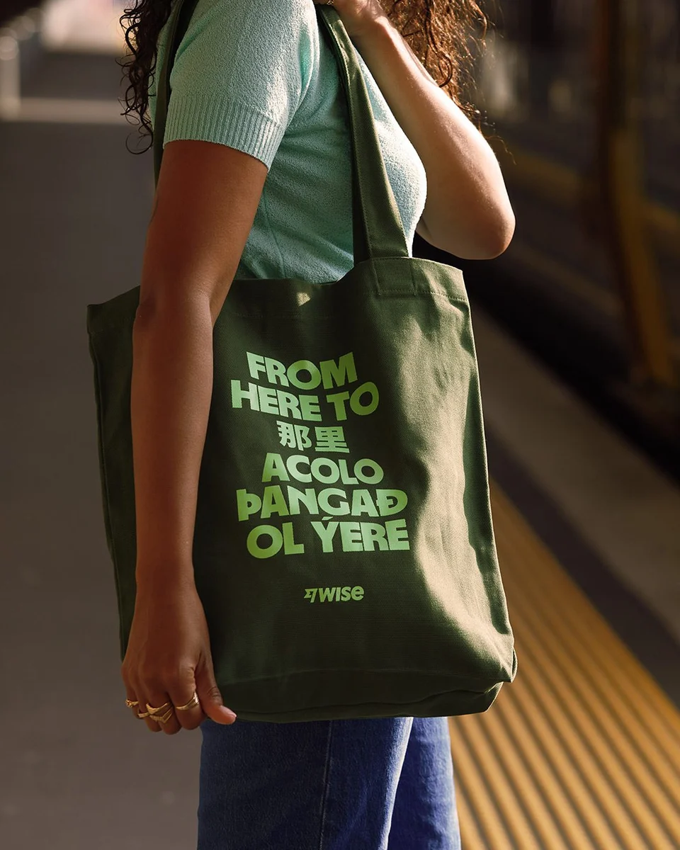 Person carrying a green Wise tote bag