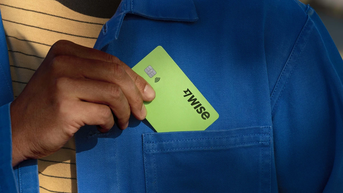 Hand pulling a green Wise card from a jacket pocket
